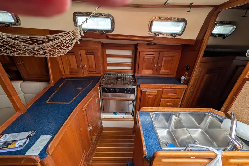 Thistle Yacht Photos Pics Cozy 2001 Tartan 3700 yacht kitchen with wooden cabinets and dual sink.