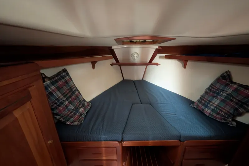 Thistle Yacht Photos Pics Cozy cabin interior of 2001 Tartan 3700 sailboat with blue bedding and plaid pillows.