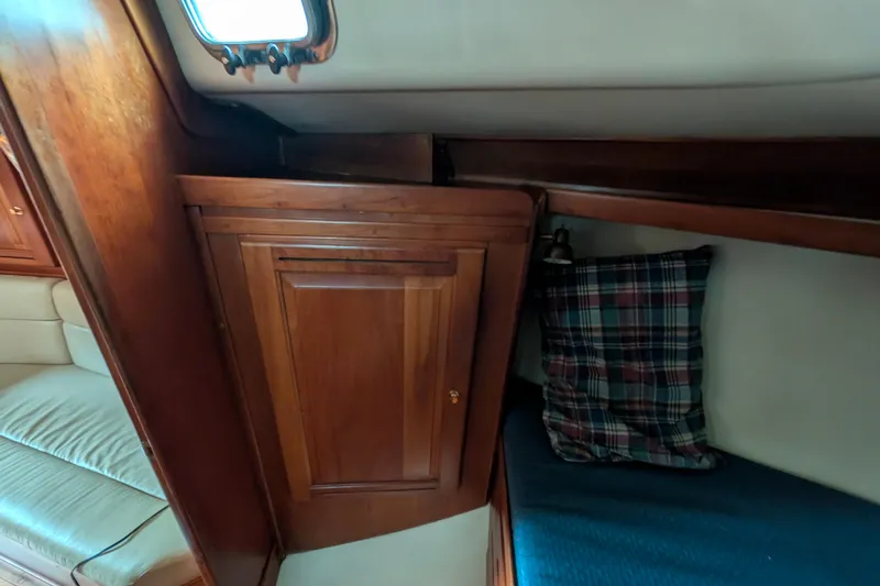 Thistle Yacht Photos Pics Cozy cabin interior of 2001 Tartan 3700 sailboat with wooden cabinetry and plaid pillow.