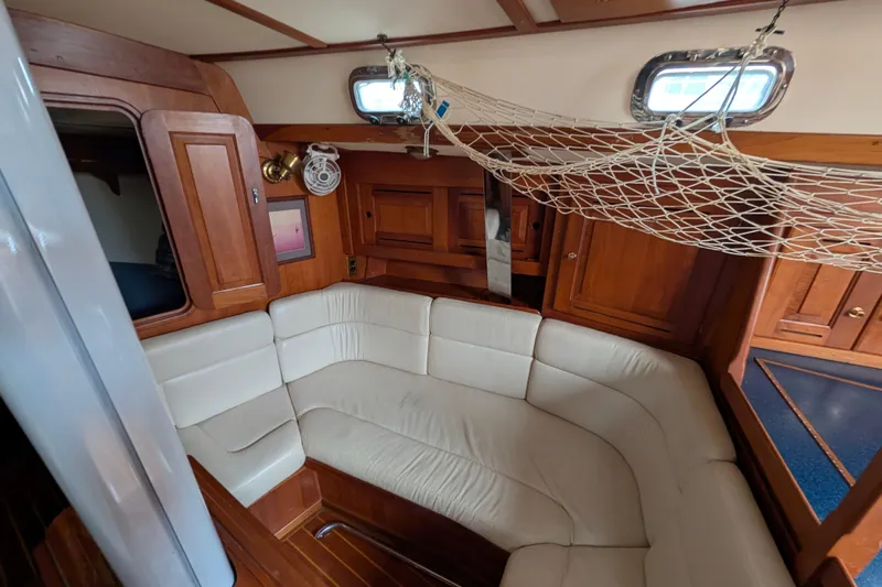 Thistle Yacht Photos Pics Interior of 2001 Tartan 3700 sailboat with cozy seating and wooden cabinetry.