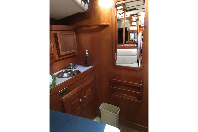Thistle Yacht Photos Pics Interior of 2001 Tartan 3700 sailboat with wooden cabinetry and compact sink area.