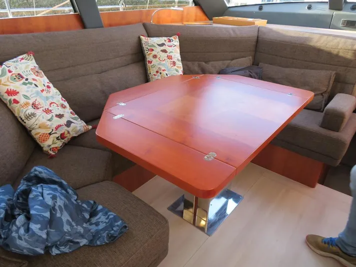  Yacht Photos Pics Luxurious interior of 2018 Moody 54 DS yacht with wooden table and cushioned seating.