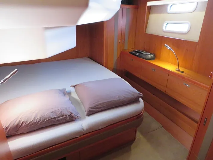  Yacht Photos Pics Luxurious cabin interior of 2018 Moody 54 DS yacht with cozy bed and wooden furnishings.