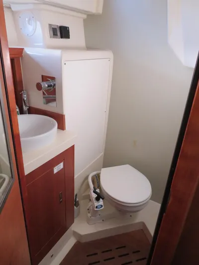  Yacht Photos Pics 2018 Moody 54 DS yacht bathroom with sink, toilet, and wooden cabinetry.
