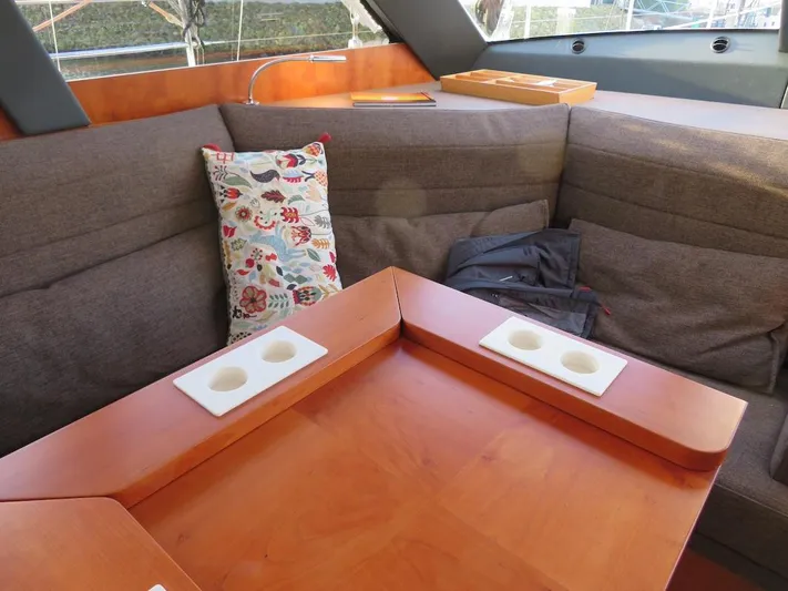  Yacht Photos Pics Cozy interior of 2018 Moody 54 DS yacht with cushioned seating and wooden table.