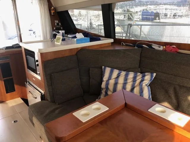  Yacht Photos Pics Cozy interior of 2018 Moody 54 DS yacht with sofa and kitchenette.