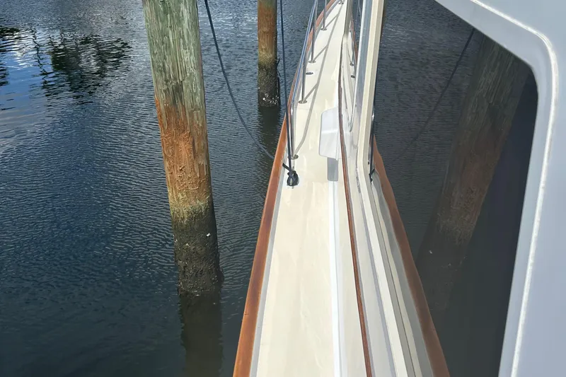 From Away Yacht Photos Pics 1987 Lyman-Morse Downeast Flybridge yacht docked, showing side deck and water reflections.