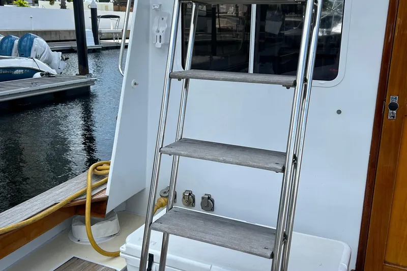 From Away Yacht Photos Pics Lyman-Morse 1987 Downeast Flybridge boat ladder and deck area by the dock.