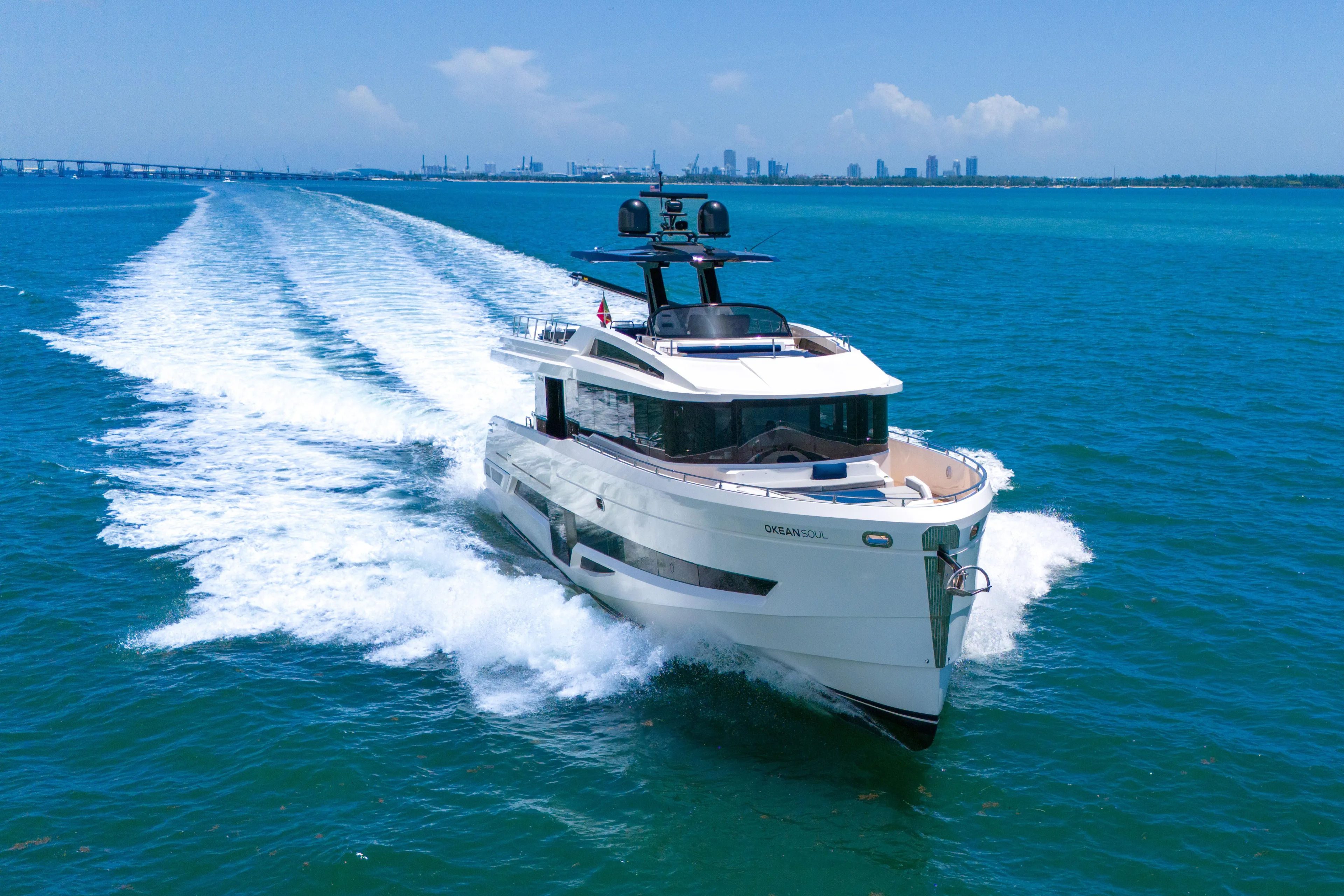  Yacht Photos Pics Luxury 2021 OKEAN 80 yacht cruising on blue ocean with city skyline backdrop.