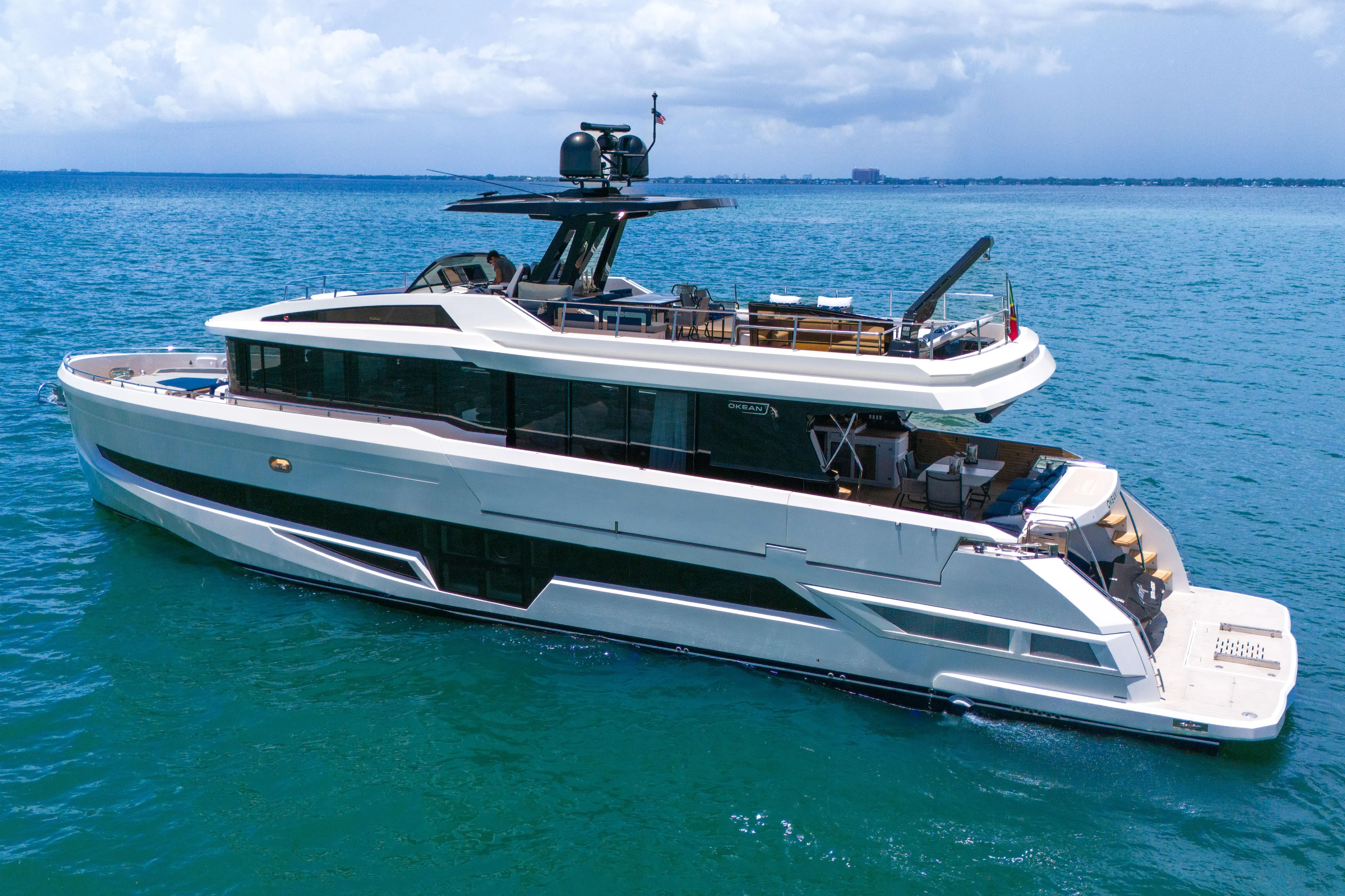  Yacht Photos Pics Luxurious 2021 OKEAN 80 yacht cruising on clear blue waters under a cloudy sky.