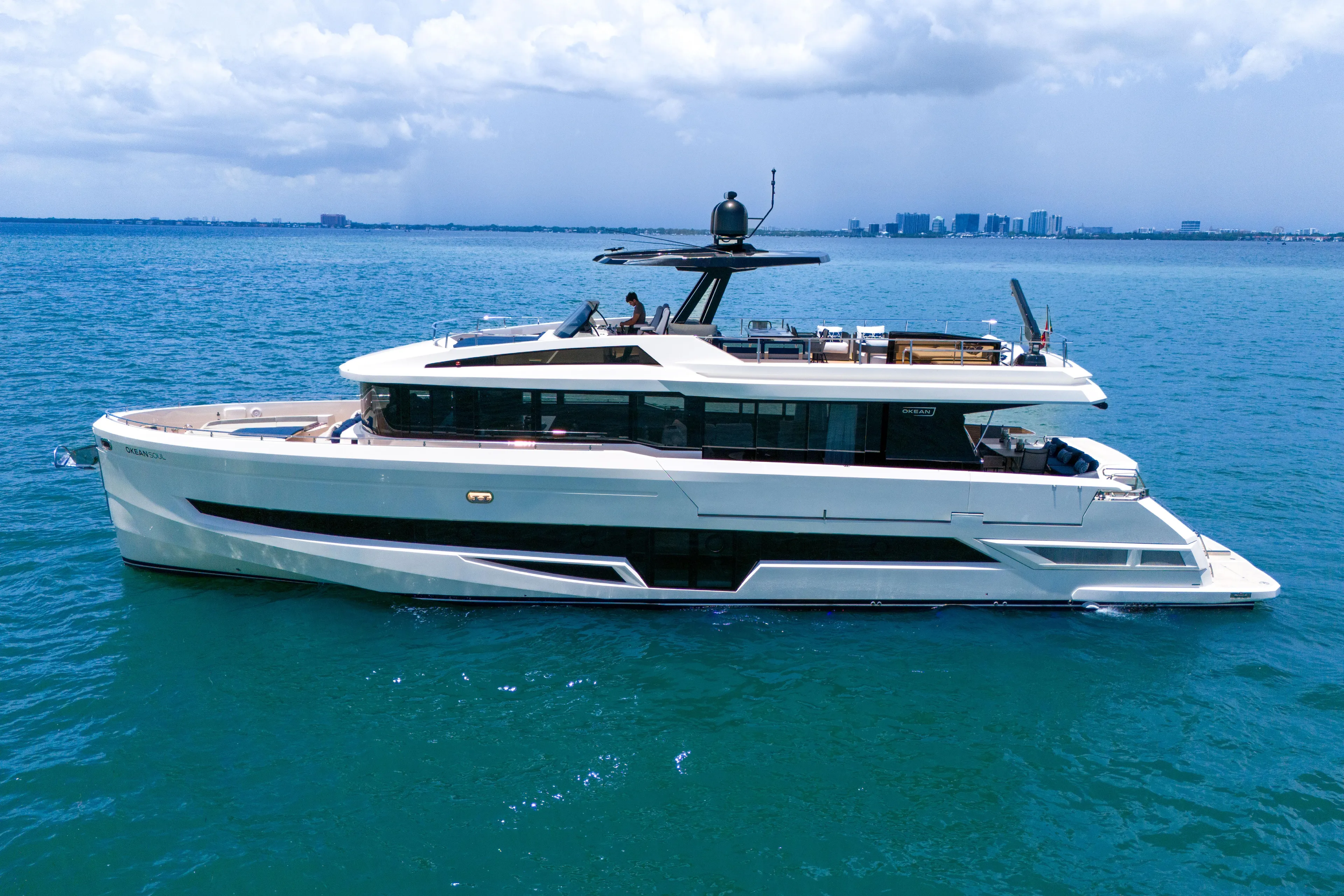  Yacht Photos Pics Luxury 2021 OKEAN 80 yacht cruising on blue ocean waters under a cloudy sky.