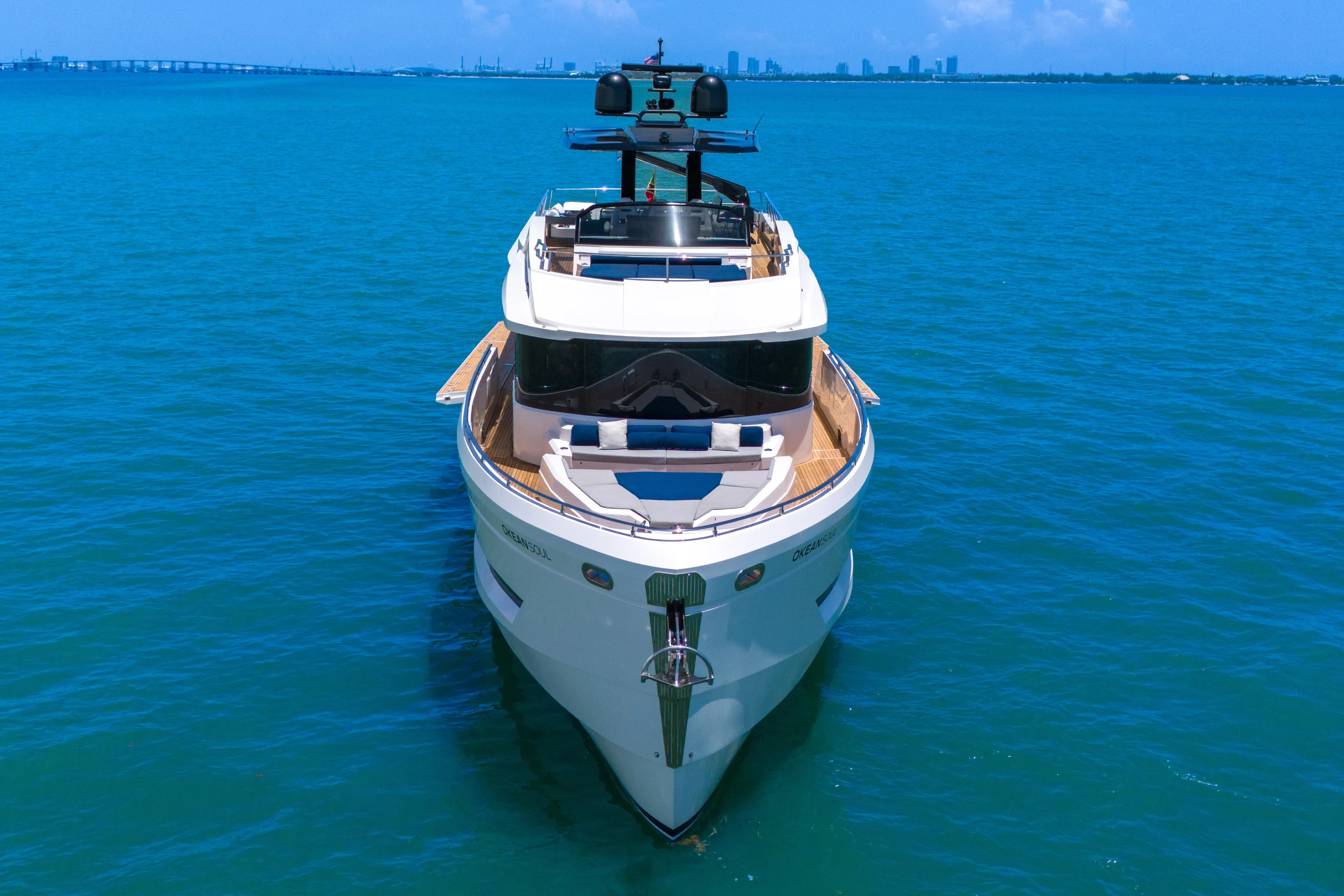  Yacht Photos Pics Luxury 2021 OKEAN 80 yacht on clear blue water, city skyline in background.
