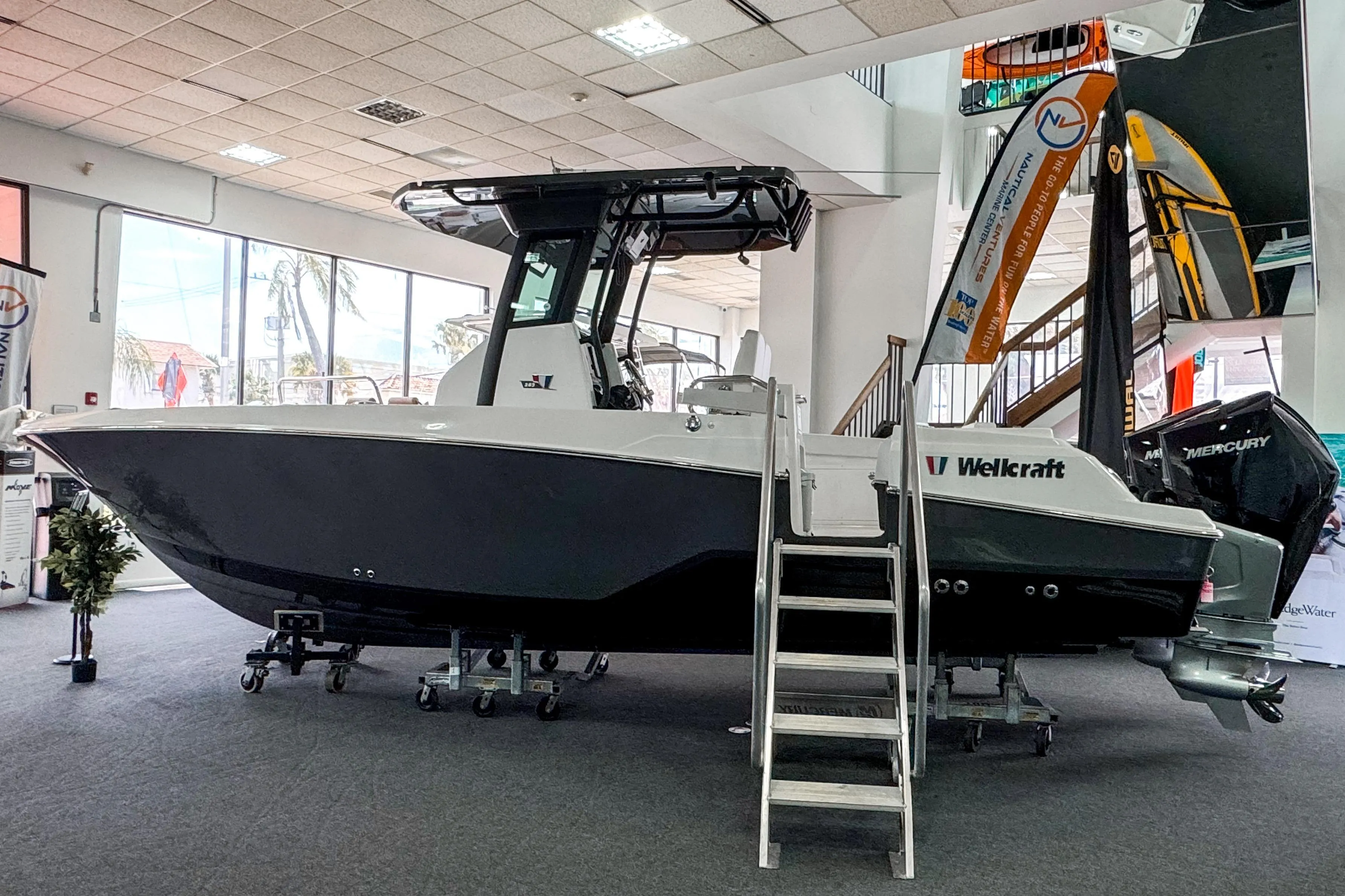 2024 Wellcraft 263 Fisherman boat displayed indoors with Mercury engine.