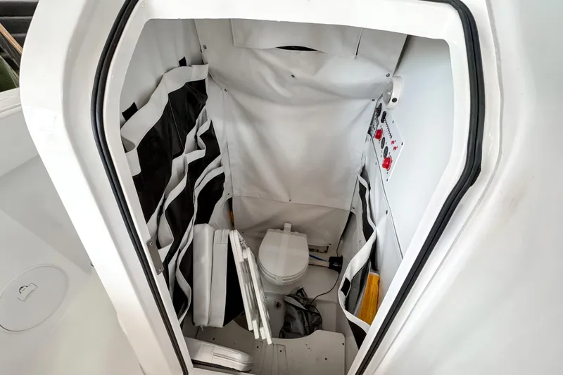  Yacht Photos Pics 2024 Wellcraft 263 Fisherman boat interior with compact marine toilet and storage.