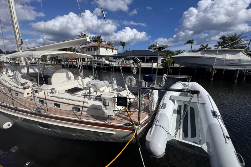 Entertainer Yacht Photos Pics 1989 Little Harbor Sloop 58' docked with inflatable dinghy, under a partly cloudy sky.
