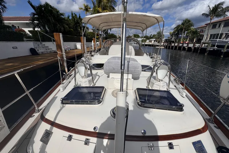 Entertainer Yacht Photos Pics 1989 Little Harbor Sloop 58' docked, showcasing deck and canopy under a partly cloudy sky.