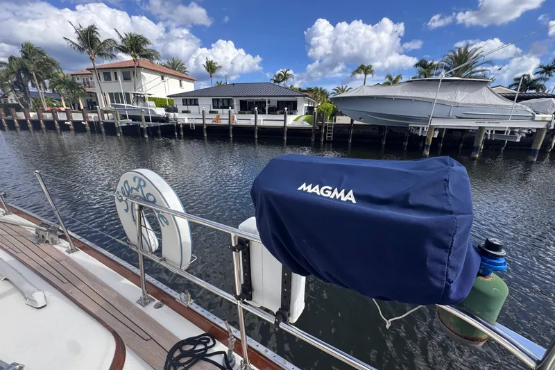 Entertainer Yacht Photos Pics 1989 Little Harbor Sloop - 58' docked near waterfront homes, clear sky, and palm trees.