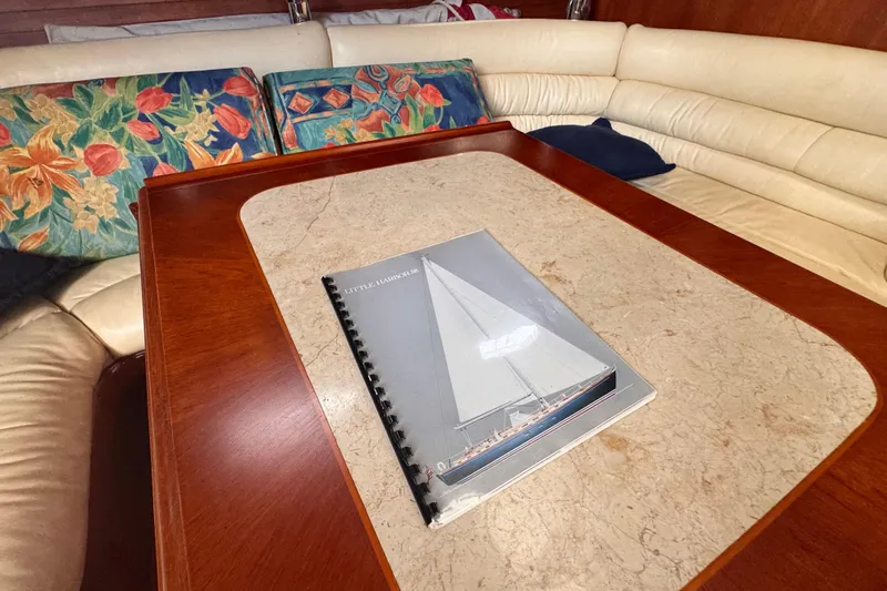 Entertainer Yacht Photos Pics 1989 Little Harbor Sloop 58' manual on a yacht's elegant wooden table.