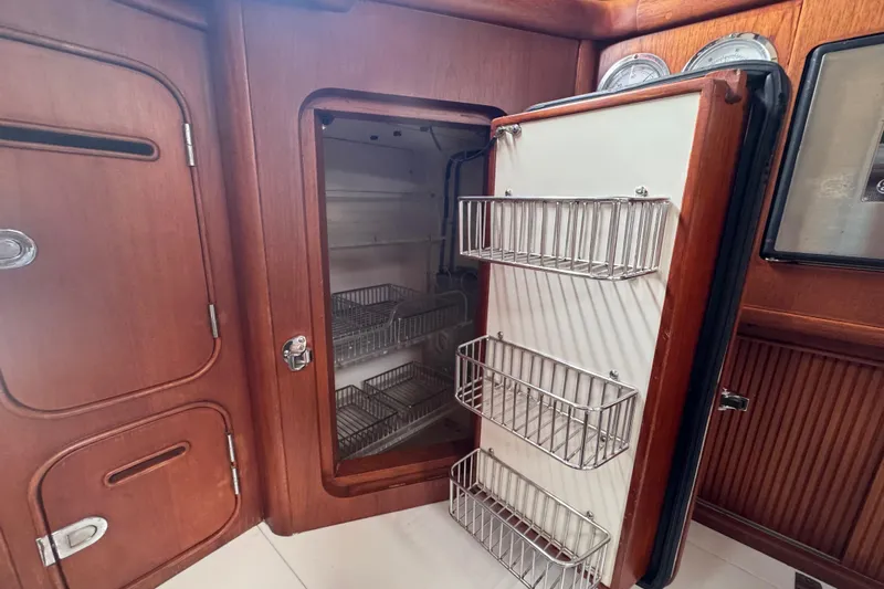 Entertainer Yacht Photos Pics Interior of 1989 Little Harbor Sloop 58' with open wooden cabinet and metal storage racks.