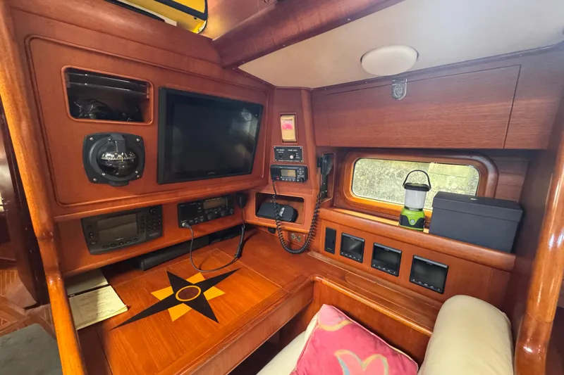 Entertainer Yacht Photos Pics 1989 Little Harbor Sloop 58' interior with navigation equipment and wooden finish.