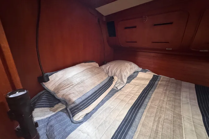 Entertainer Yacht Photos Pics Cozy cabin interior of 1989 Little Harbor Sloop 58' with striped bedding.