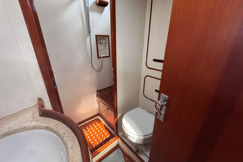 Entertainer Yacht Photos Pics 1989 Little Harbor Sloop 58' bathroom with shower and toilet, featuring wooden accents.