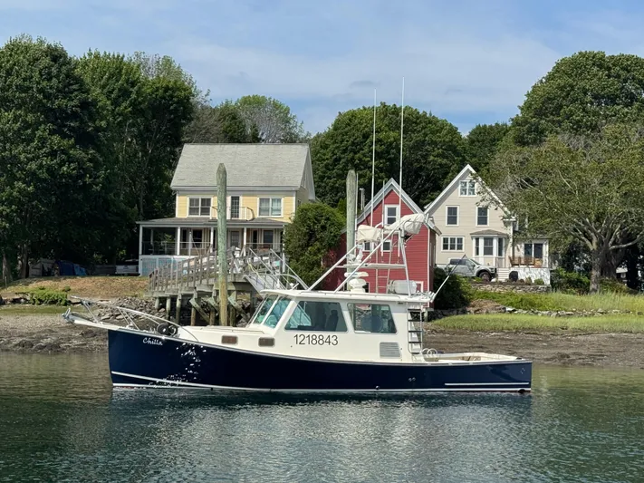 Chilla Yacht Photos Pics 2009 Northern Bay 36 boat docked near colorful houses and lush trees.