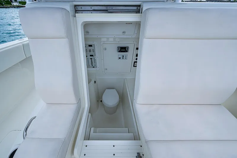 Fishy Business Yacht Photos Pics 2014 SeaVee 390B boat interior with white seating and compact marine toilet.
