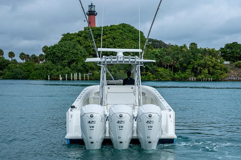 Fishy Business Yacht Photos Pics 2014 SeaVee 390B boat with triple 425 V8 engines near a lush island and lighthouse.
