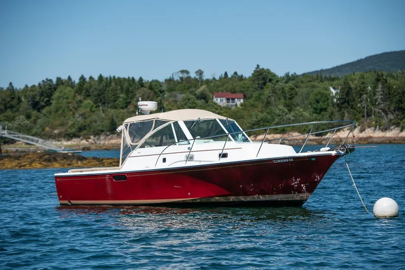 Robin Yacht Photos Pics 2005 Hunt Yachts Surfhunter 29 in scenic coastal waters, anchored near lush greenery.