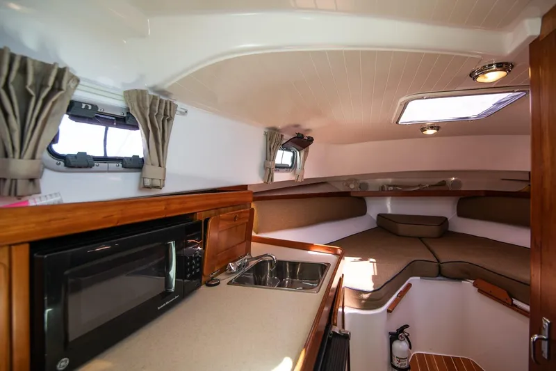 Robin Yacht Photos Pics 2005 Hunt Yachts Surfhunter 29 interior with kitchenette and cozy seating area.