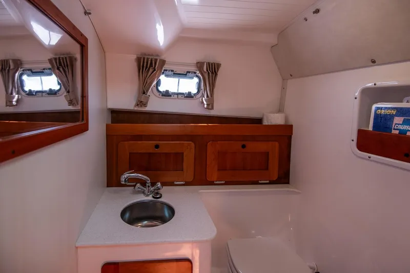 Robin Yacht Photos Pics 2005 Hunt Yachts Surfhunter 29 bathroom with sink, mirror, and storage cabinets.