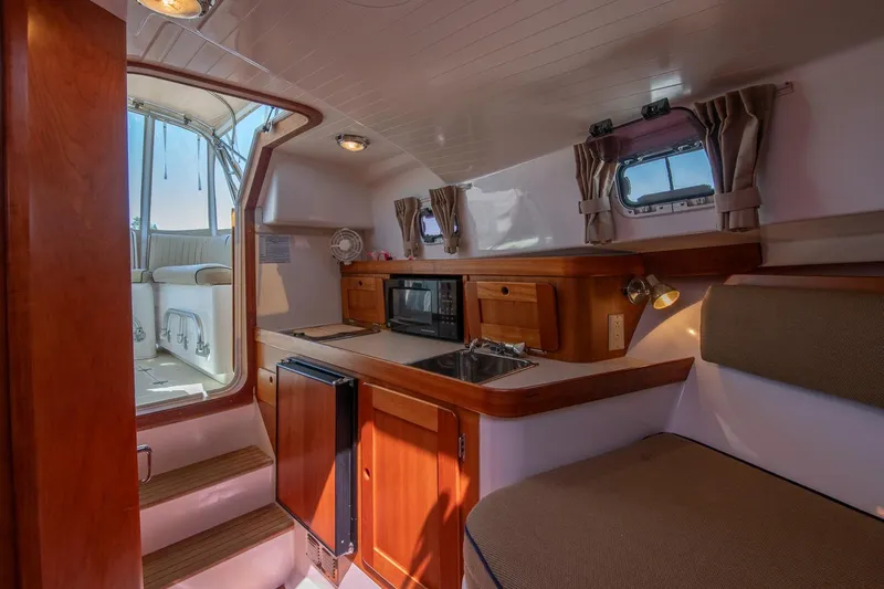 Robin Yacht Photos Pics Interior of 2005 Hunt Yachts Surfhunter 29 with kitchenette and seating area.