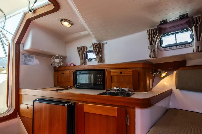 Robin Yacht Photos Pics 2005 Hunt Yachts Surfhunter 29 interior with kitchenette, featuring wood cabinetry and modern amenities.
