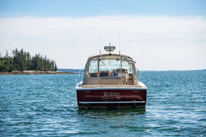 Robin Yacht Photos Pics 2005 Hunt Yachts Surfhunter 29 on serene water, distant forested shoreline.