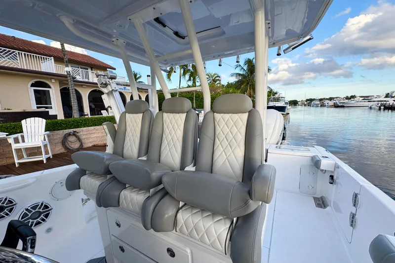  Yacht Photos Pics 2021 Everglades 335 Center Console boat with luxurious seating, docked by waterfront homes.