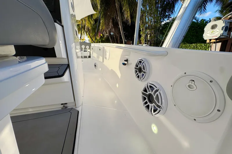  Yacht Photos Pics 2021 Everglades 335 Center Console boat interior with speakers and seating, under palm trees.