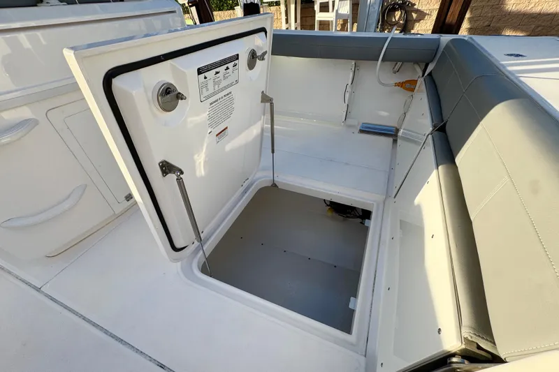  Yacht Photos Pics 2021 Everglades 335 Center Console boat with open storage compartment and cushioned seating.