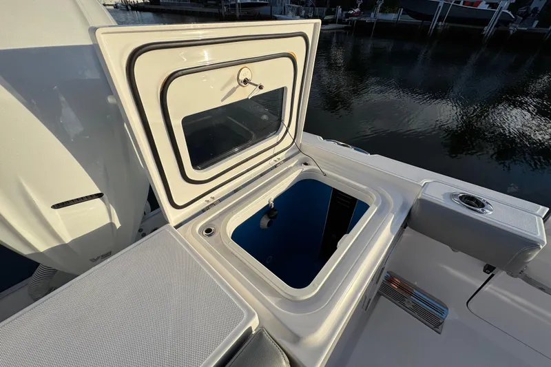  Yacht Photos Pics 2021 Everglades 335 Center Console boat with open storage compartment by the water.