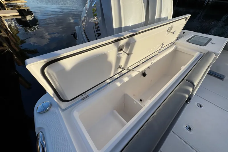  Yacht Photos Pics Open storage compartment on 2021 Everglades 335 Center Console boat, docked by water.