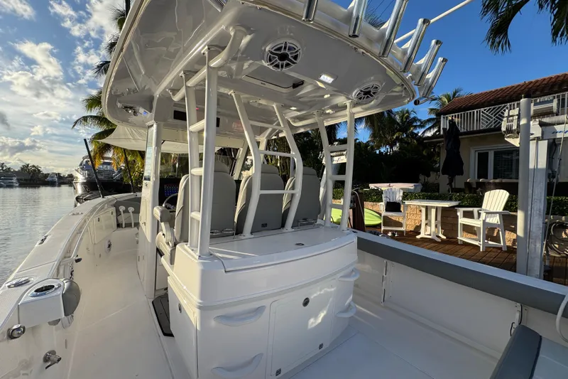  Yacht Photos Pics 2021 Everglades 335 Center Console boat docked by waterfront home, sunny day.