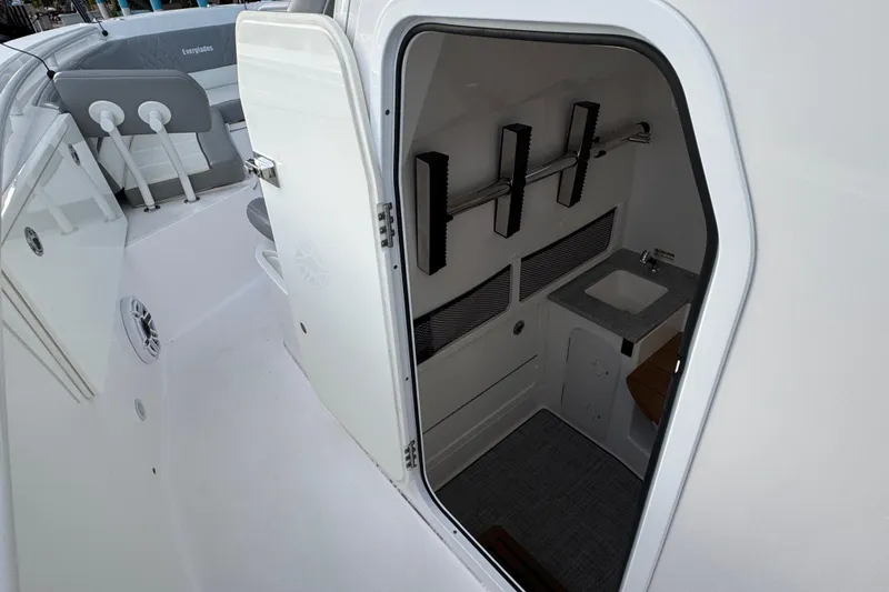  Yacht Photos Pics 2021 Everglades 335 Center Console boat interior with open door and compact sink area.