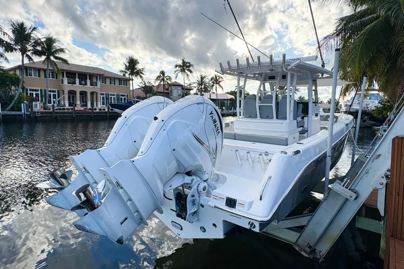 Yacht Photos Pics 2021 Everglades 335 Center Console boat docked by waterfront homes, featuring twin Yamaha engines.