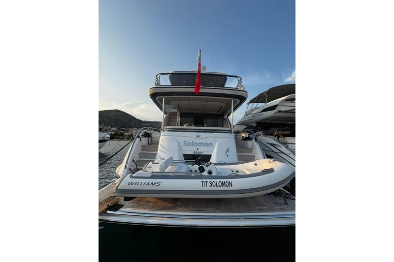 Solomon Yacht Photos Pics 2025 Princess Y72 yacht docked with tender boat, scenic marina backdrop.