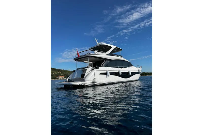 Solomon Yacht Photos Pics Luxurious 2025 Princess Y72 yacht on serene blue waters under a clear sky.