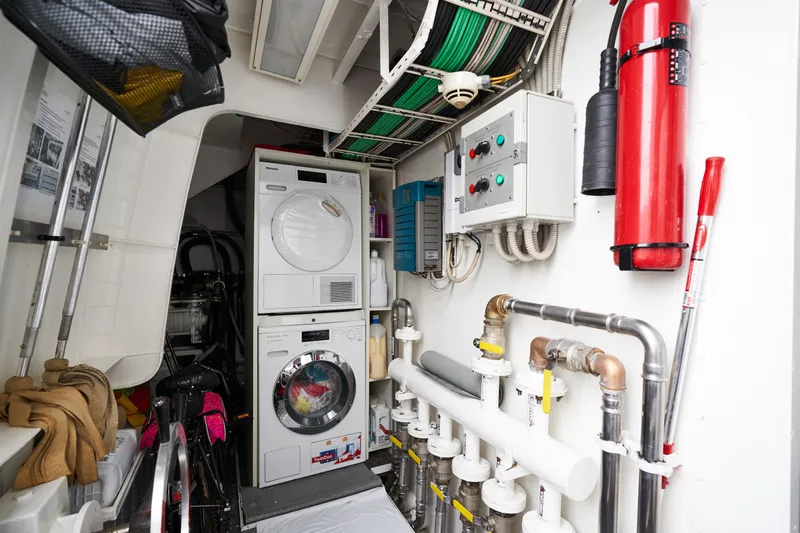 L'instant IV Yacht Photos Pics Laundry and utility room on a 2009 Castagnola Navetta 33 yacht with washer, dryer, and fire extinguisher.