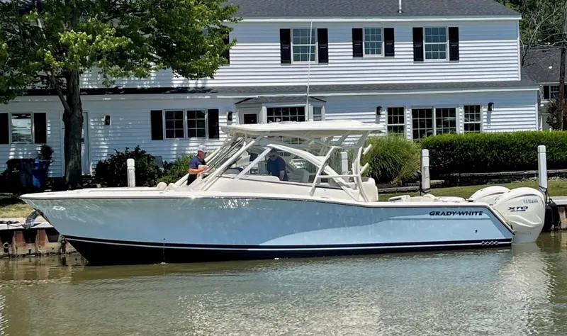  Yacht Photos Pics 2024 Grady-White Freedom 335 boat docked near a white house.