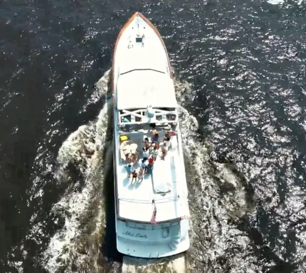 Miss Emily Yacht Photos Pics Aerial view of 1990 Broward Motor Yacht Extraordinaire cruising with passengers on deck.
