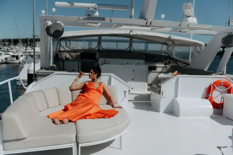 Miss Emily Yacht Photos Pics Woman in orange dress relaxing on 1990 Broward Motor Yacht Extraordinaire deck.