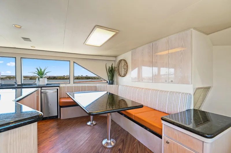 Miss Emily Yacht Photos Pics Luxurious 1990 Broward Motor Yacht interior with modern dining area and scenic views.